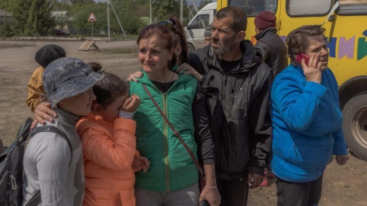 Oksana Velychko (C), 45 anos, que foi evacuada com seus filhos e parentes do distrito de Vovchansk se reúnem após chegar a um ponto de evacuação na região de Kharkiv, em 12 de maio de 2024. (Foto de Roman PILIPEY/AFP)