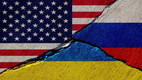 Un muro di cemento incrinato con bandiere dipinte di Stati Uniti, Russia e Ucraina